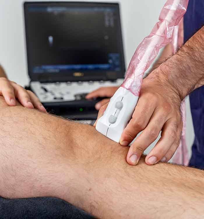 Doctor using ultrasound to examine patient’s knee