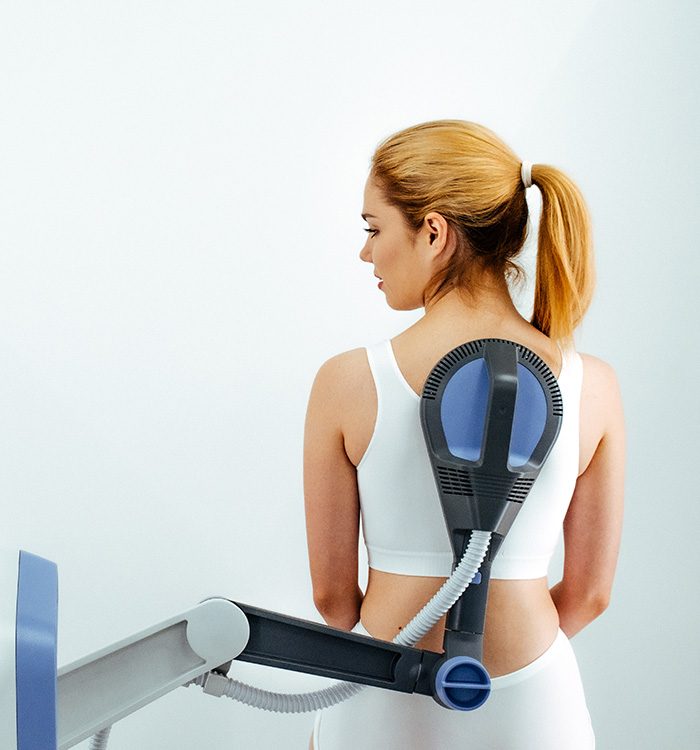 Woman receiving electromagnetic therapy for her back
