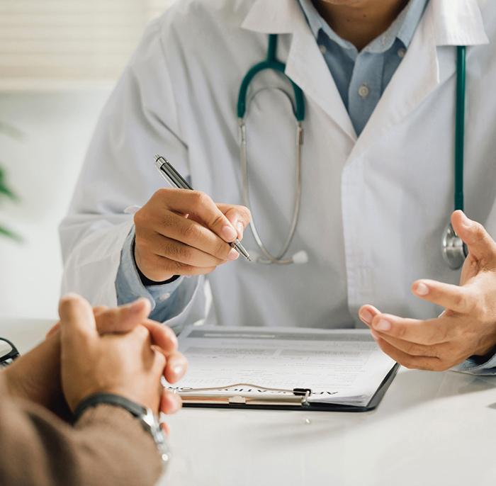 Doctor and patient sitting at desk, talking