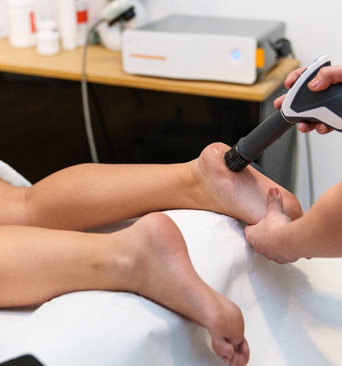 Doctor administering shockwave therapy on patient’s heel