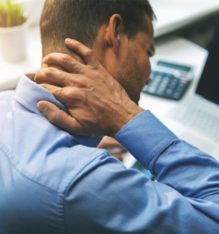 Man sitting at computer, dealing with neck pain