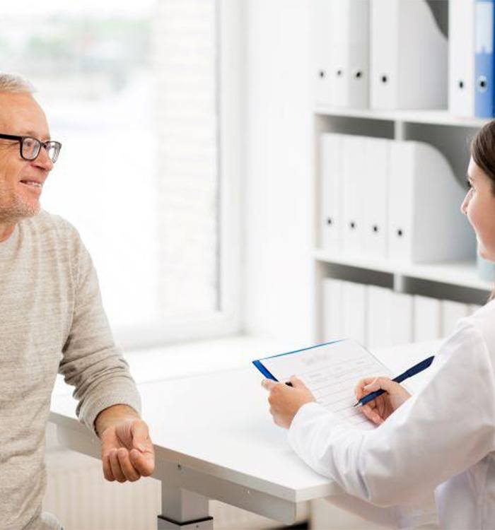 Older man speaking to medical team member