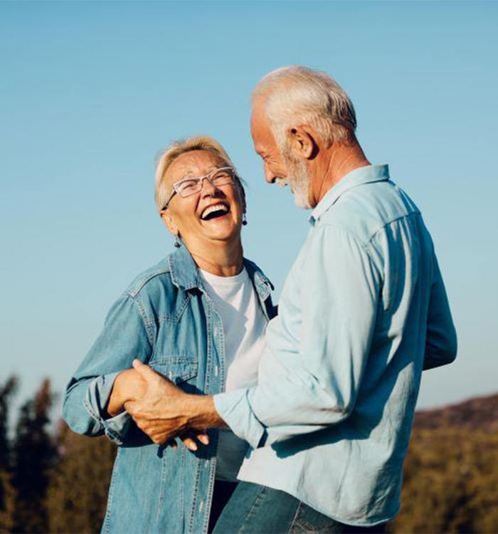 Senior man and wife dancing happily outdoors