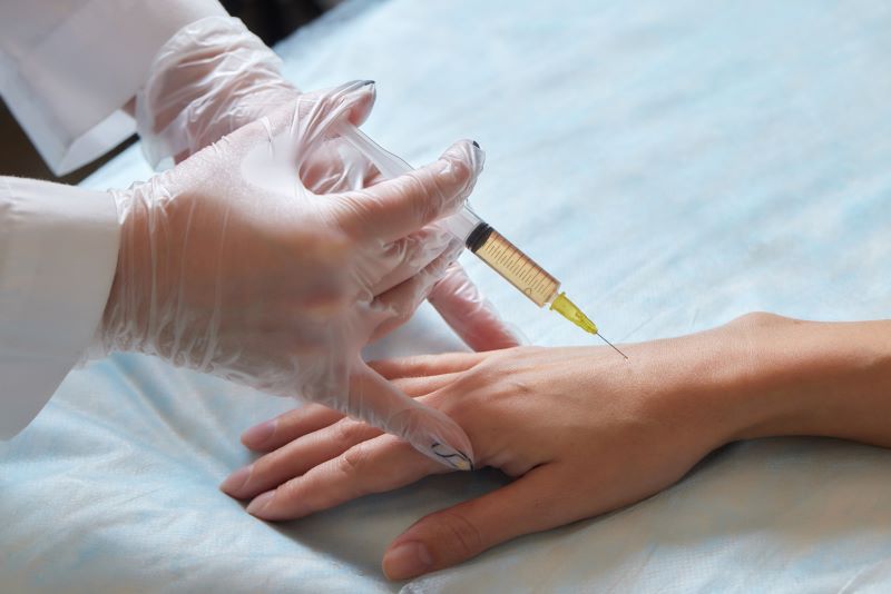 Patient receiving stem cell therapy injection in hand