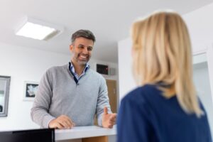 Happy patient talking with medical office team member